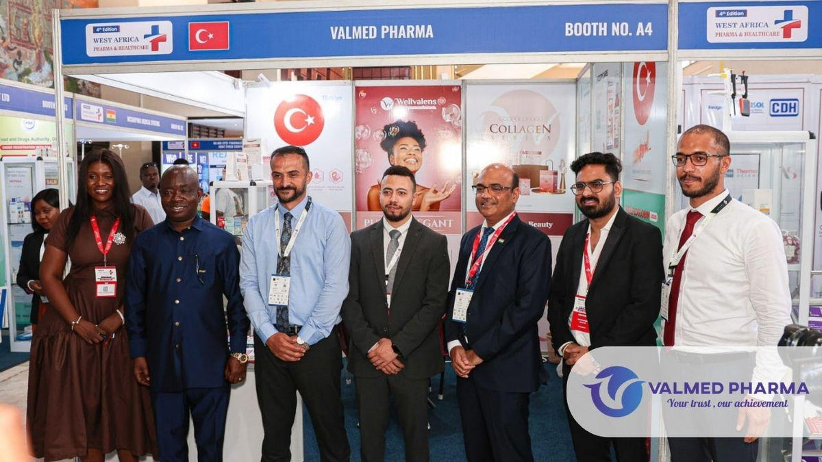 Group posing at Valmed Pharma’s Booth A4 at the West Africa Pharma and Healthcare exhibition, with Wellvalens product displays.