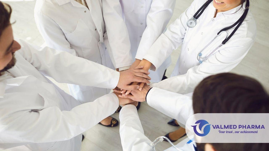 Healthcare professionals in white coats stacking their hands together, with Valmed Pharma branding.